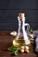 Obraz na płótnie Canvas Healthy Peanut oil in glass bottles. Dark wooden background Copy space