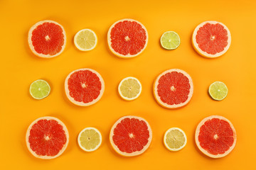 Flat lay composition with tasty ripe grapefruit slices on orange background