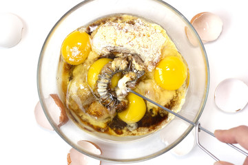 CoCorn and rice flour, coconut sugar, four eggs in the transparent plate. Making a cake. Mixing the dough. White background. Copy space. Place for text and design. Top view. Flat lay. Gluten-free reci