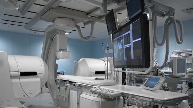 Modern medical robot for human diagnostic in operating room. Robotic medicine. Empty sterile operating room or lab with monitors and moving parts of futuristic device