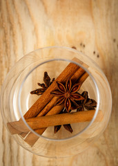  spices anise cinnamon in a transparent glass with a branch of spruce, winter holiday theme