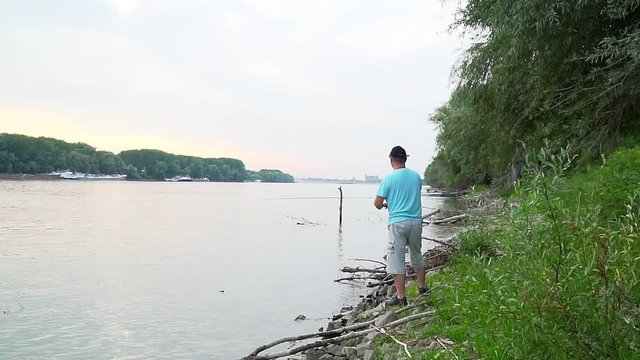 Man is fishing with lure on Danube river