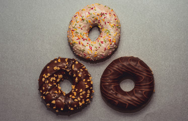 Przepyszny donut ze smacznie wyglądającymi dodatkami na szarym tle, fotografia kulinarna