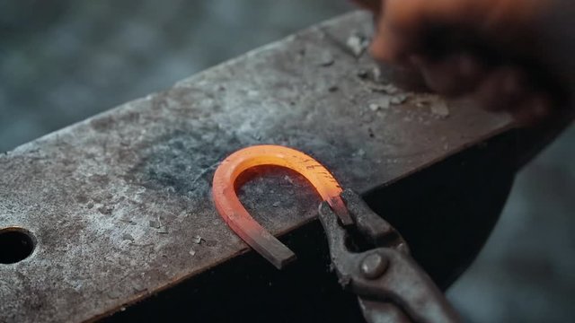 A blacksmith working on a horseshoe