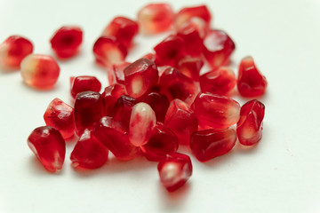 Red pomegranate seeds, white background. Mono Shooting. Juicy bright red fruit. Love.