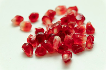 Red pomegranate seeds, white background. Mono Shooting. Juicy bright red fruit. Love.