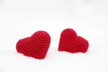 Love hearts, Valentine's card, two red knitted symbols of passion in the snow. Background for romantic event, celebration or winter weather