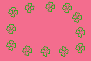 Pink background with frame of green leaves of clover. St.Patrick 's Day. Copy space