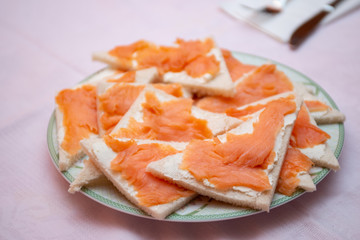 salmon canapes in the foreground on a laid table
