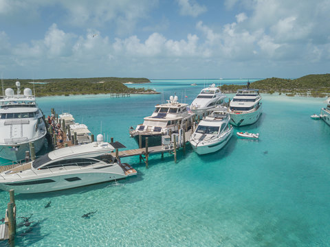 Yachts  in the bay with sharks in front, Exuma, Bahamas. Travel concept.
