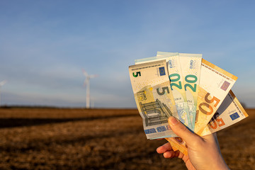 Klimageld Symbolfoto Windbürgergeld Windrad mit Geldscheinen