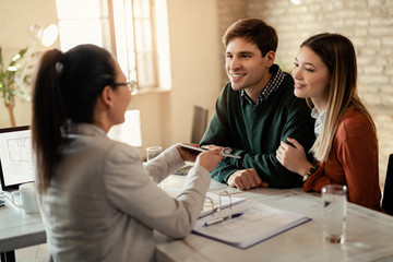 Young couple having a meeting with real estate agent in the office.