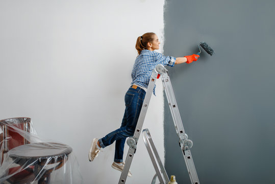 Female House Painter In Gloves Paints The Wall