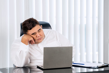 Portrait of fat businessman sleeping while working