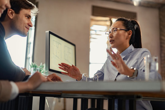 Below View Of Asian Insurance Agent Talking To Clients During A Meeting.