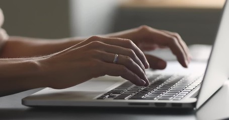 Female hands typing on laptop at desk, close up view - Powered by Adobe
