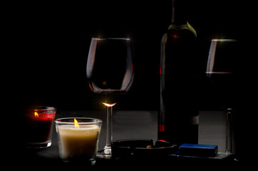 Red wine bottle, glass of wine and candles