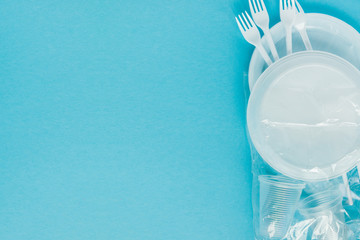 Plastic dishes on a blue background. Disposable tableware