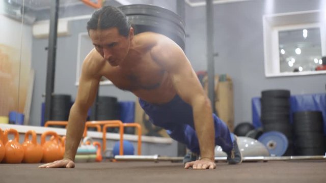 Man does push-ups with weight on his back