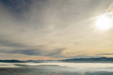 Fog in mountains before sunrise, mountain valley with clouds. View to mountains of the Carpathians