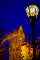 On the right side you can see a historic lantern. In the unfocussed background stands a historic...
