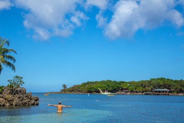A young man entering the Caribbean Sea at West End Beach on Roatan Island. Honduras