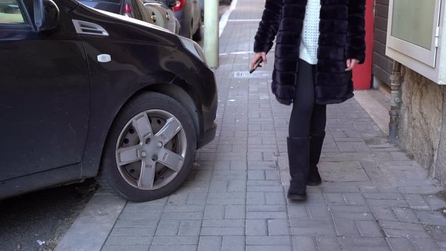 Driver parking his black car on the sidewalk, violation of parking rules, forbidden place for car parking. Penalty is obligatory for violators. Street blocking by illegal car parking