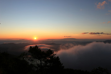 Beautiful scenery of mountain with mist sea, golden light shines on sky and sunrise up from the horizon at view point of Phu chi phoe in the early morning, Khun Yuam, Mae Hong Son, Thailand