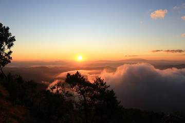 Beautiful scenery of mountain with mist sea, golden light shines on sky and sunrise up from the horizon at view point of Phu chi phoe in the early morning, Khun Yuam, Mae Hong Son, Thailand