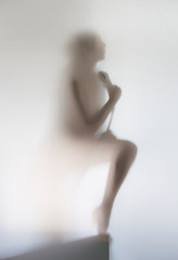 Obraz premium Silhouette of a beautiful woman in bathroom with shower, behind a curtain