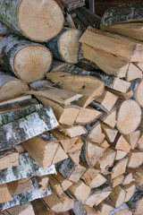 Woodpile of birch firewood near the village house