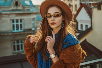 Outdoor close up fashion portrait of elegant fashionable woman wearing hat, trendy sunglasses,...