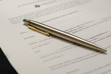 Signature of documents. The silver pen lies on the documents. Business. Subscription agreement.