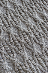 Gray knitted plaid with a large geometric pattern. Close-up.