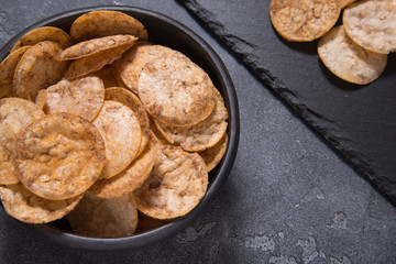Top view pile of organic, crispy, baked, whole grain rice chips with spices. Gluten free healthy snack. Food background