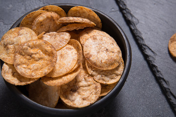Top view pile of organic, crispy, baked, whole grain rice chips with spices. Gluten free healthy snack. Food background