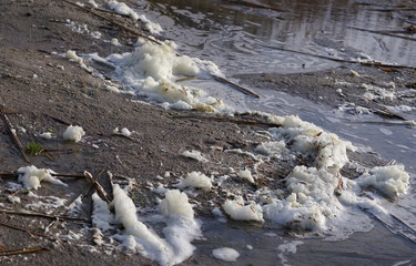 The problem of environmental protection. Polluted lake - foam on the shore