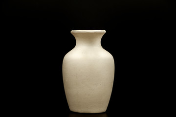 Pottery, vase, jug of white clay isolated on a black background. Pottery mockup made of white clay on a black background. Layout for design a white clay pottery vase.