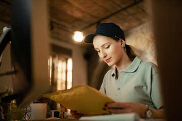Young female courier working in the office.