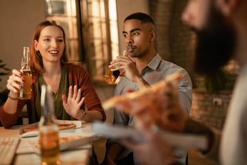 Young happy colleagues drinking beer and communicating on lunch break in the office.