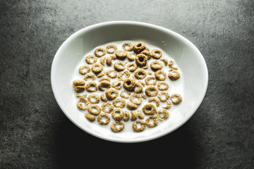 Corn Flakes and milk in a white bowl