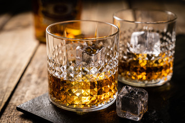 Whiskey in glasses on wood background, copy space, toned