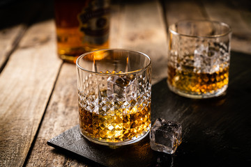 Whiskey in glasses on wood background, copy space, toned