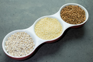 Bukwheat, pearl barley and millet on black background