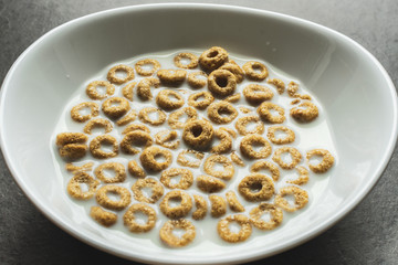 Corn flakes with milk in white bowl