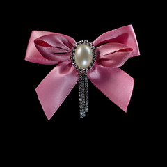 Pink ribbon with pearl isolated on black background