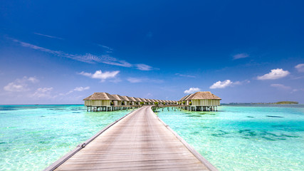 Fantastic landscape of Maldives beach. Tropical panorama, luxury water villa resort with wooden pier or jetty. Luxury travel destination background for summer holiday and vacation concept.