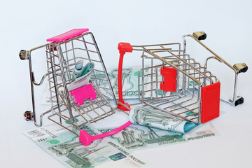 Banknotes - Russian rubles and carts from the supermarket. The purchasing power of the currency. Consumer basket