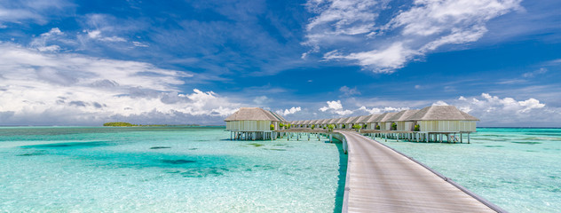 Panoramic landscape of Maldives beach. Tropical panorama, luxury water villa resort with wooden...