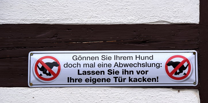 Schild an einer Fassade: Lassen Sie den Hund vor der eigenen T&uuml;r kacken!